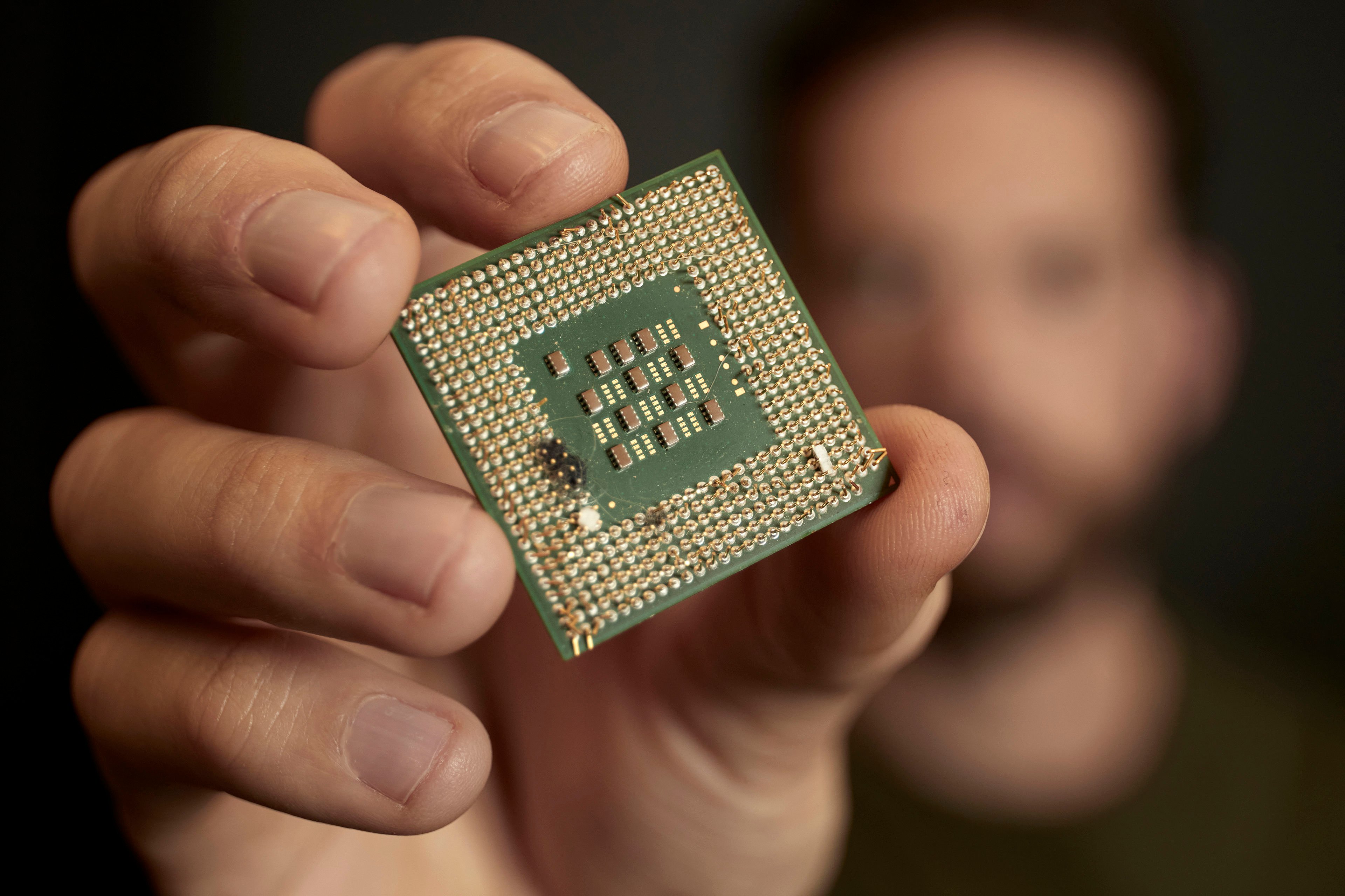 Eine Nahaufnahme einer Hand, die ein Stück Elektronikschrott hält