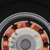 Close-up of an electric motor showing copper windings and other internal components against a black background.